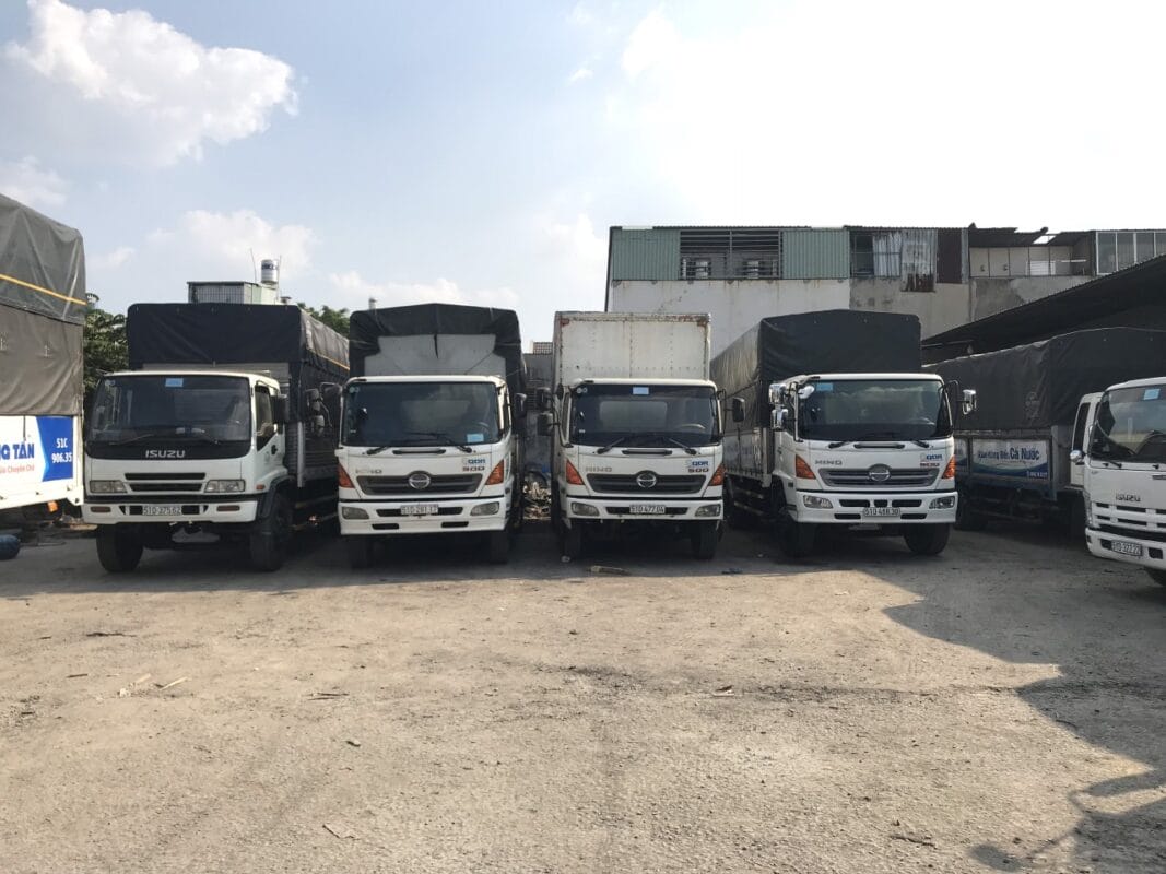 Xe tải vận chuyển hàng hóa, máy móc và thiết bị trong dịch vụ chuyển kho xưởng.